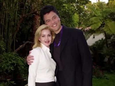 Marco Garibaldi is side hugging Priscilla Presley as they are posing for the picture.